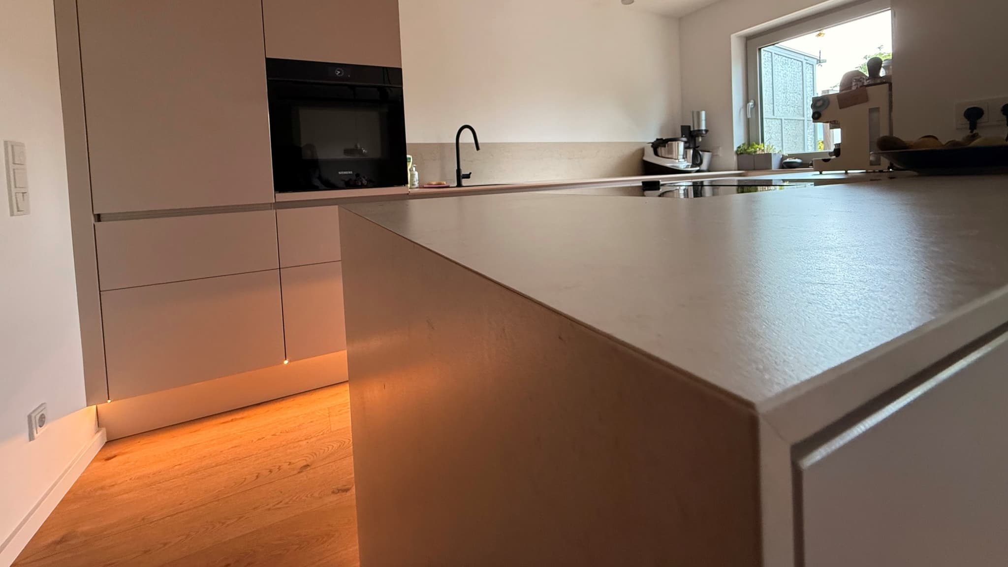 Perfektion im Detail: Arbeitsplatte und Wange auf Gehrung - Minimalistische Küche im Raum München